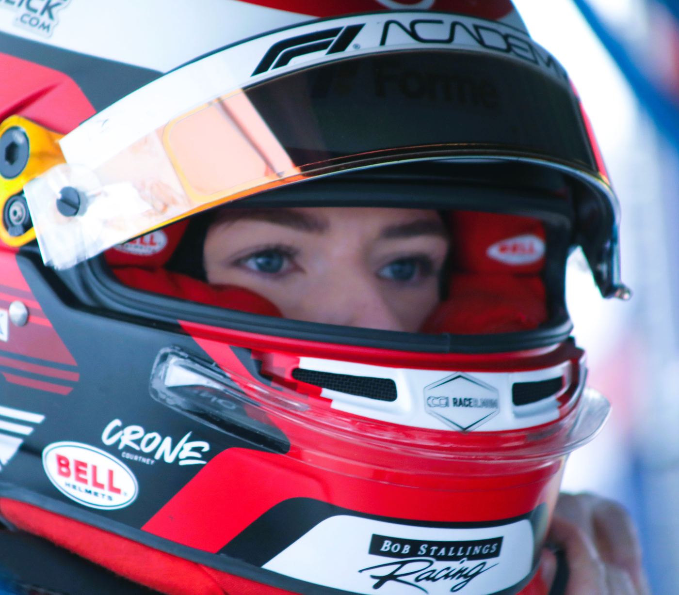 Close portrait of Courtney Crone’s helmet, her name visible above the visor.